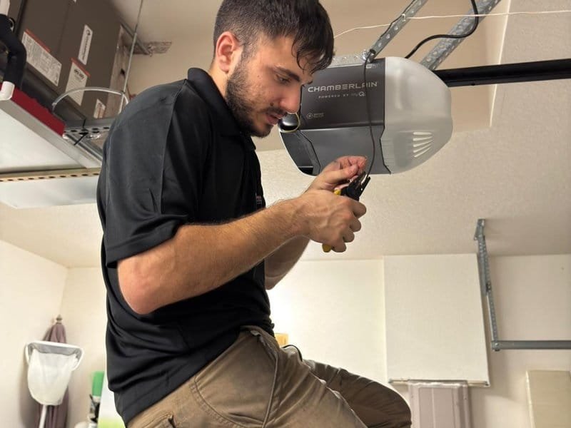 Close view of a technician checking sectional-door hardware with a hand tool