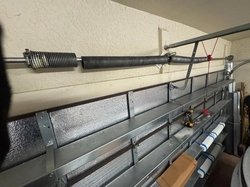 Torsion spring and lift shaft above the top garage door panel
